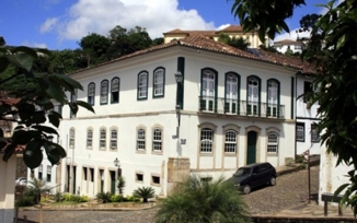 Colonial-style Luxor Ouro Preto Pousada with white facade and arched windows in historic Minas Gerais, Brazil. 