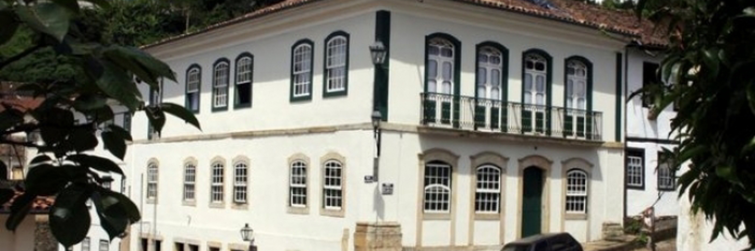 Colonial-style Luxor Ouro Preto Pousada with white facade and arched windows in historic Minas Gerais, Brazil. 
