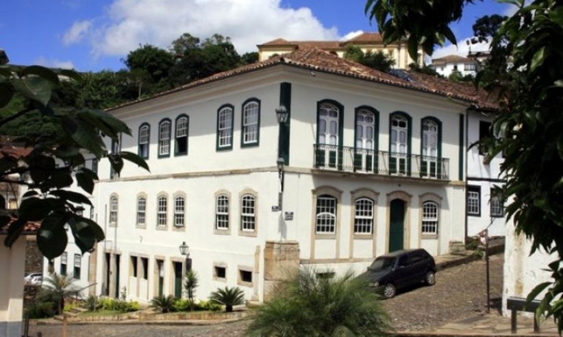 Colonial-style Luxor Ouro Preto Pousada with white facade and arched windows in historic Minas Gerais, Brazil. 
