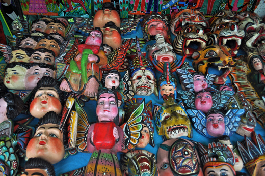 Hand-painted Mexican folk art masks and figurines on display at a Saturday bazaar in Colonial Mexico. 