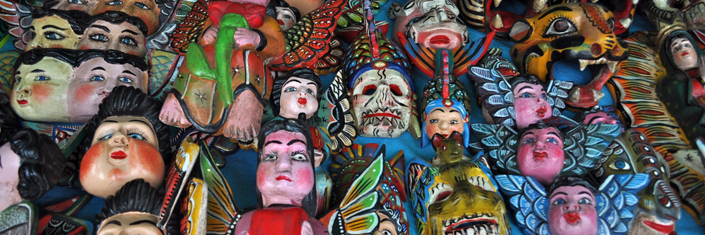 Hand-painted Mexican folk art masks and figurines on display at a Saturday bazaar in Colonial Mexico. 