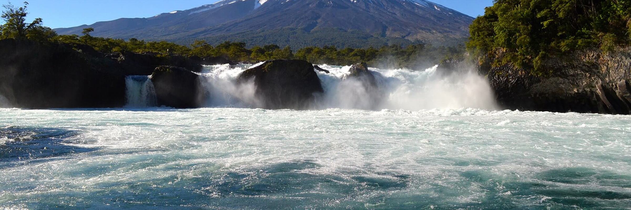 Osorno Volcano rises behind the Petrohue Falls in Chile's Lake District, a highlight of northern Patagonia's natural scenery. 
