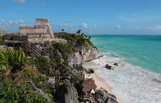Ancient Tulum ruins on a cliff above the Caribbean Sea, Yucatan Peninsula, Mexico, with turquoise waters and blue sky. 