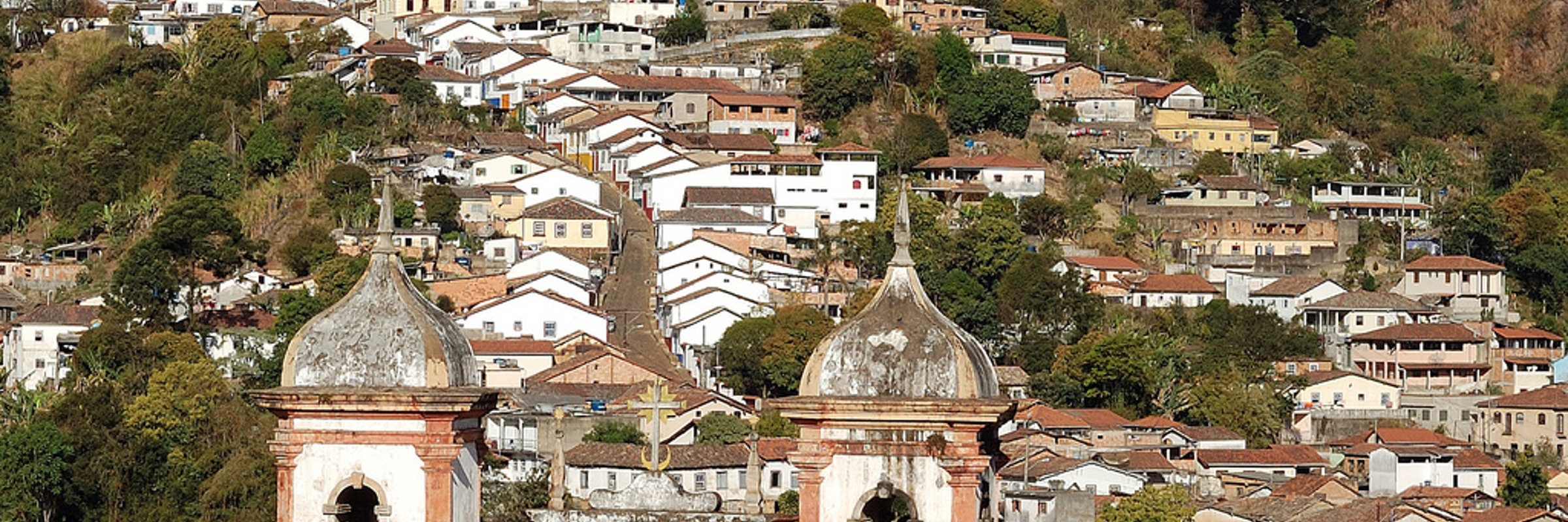 Panoramic view of Ouro Preto with colonial rooftops and historic churches nestled in the hills of Minas Gerais, Brazil. 