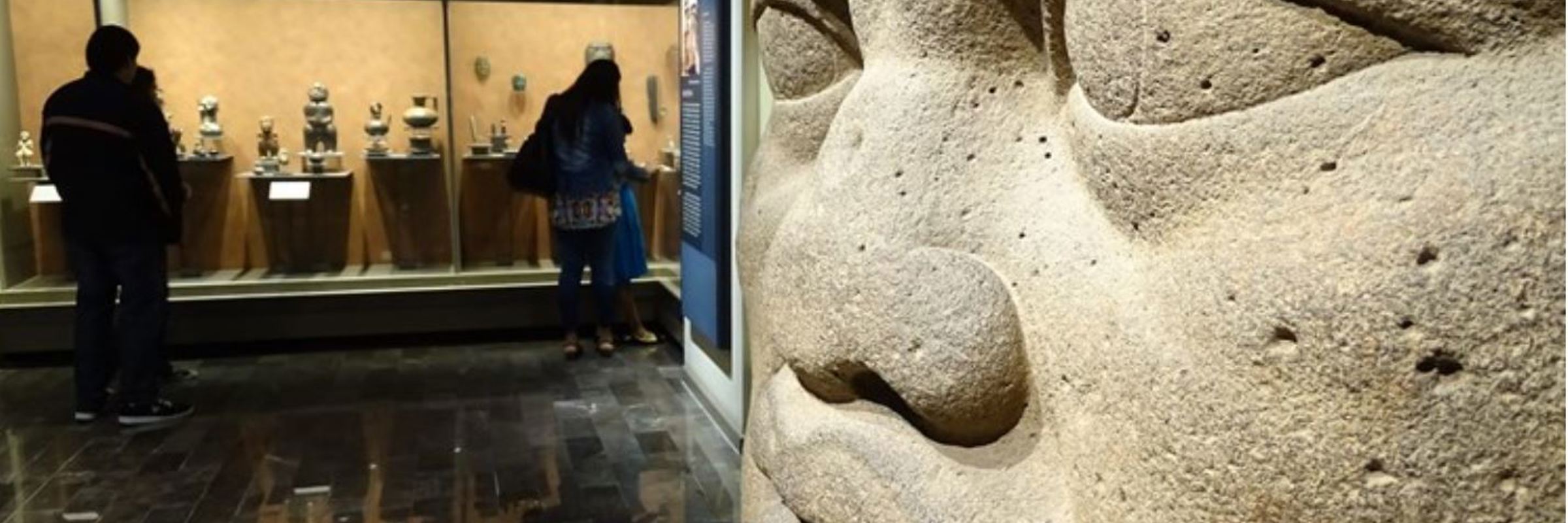 olmec colossal head and visitors at the National Museum of Anthropology, Mexico City, showcasing ancient Mesoamerican artifacts. 