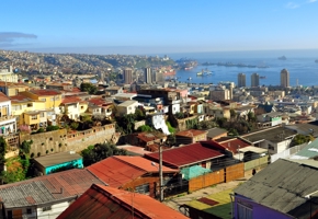 Colorful hillside homes overlook the bustling port and bay of Valparaiso under clear blue skies on Chile's Pacific coast. 