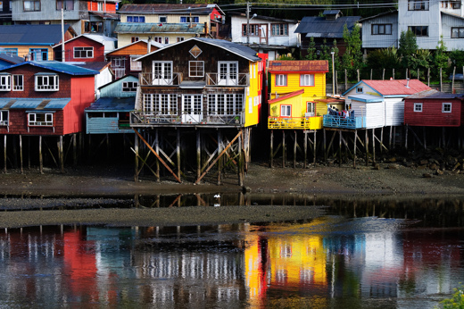 Colour palafitos stilt houses reflected in the water at Castro on Chiloe Island, Northern Patagonia, Chile. 