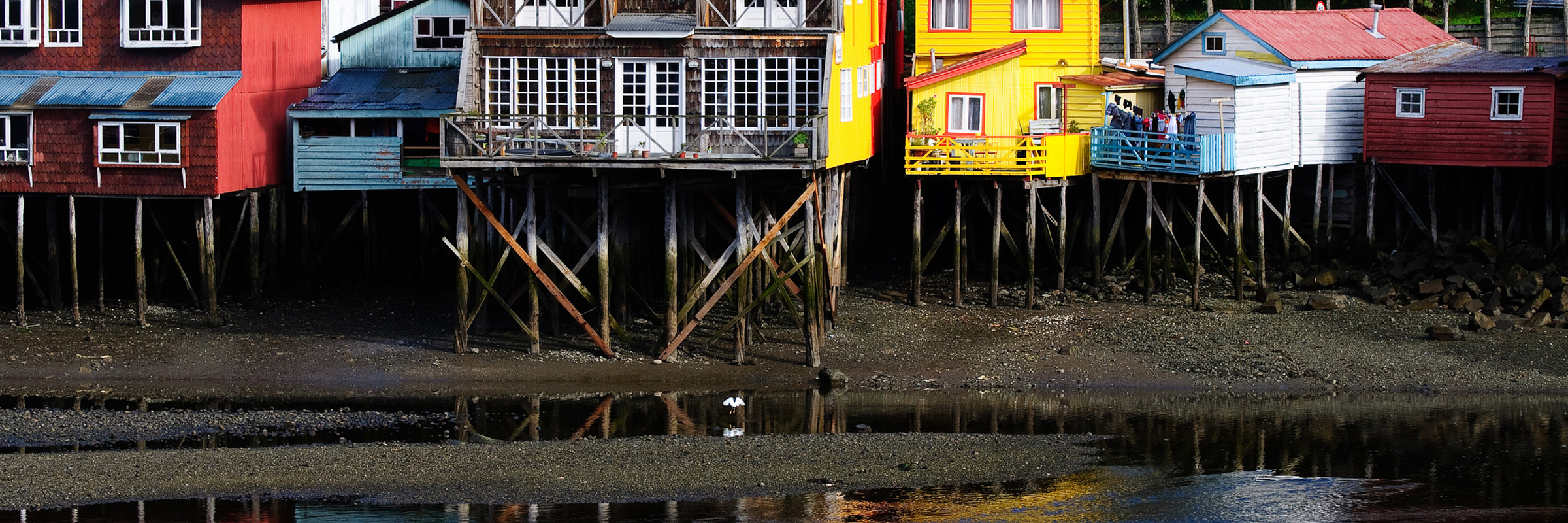 Colour palafitos stilt houses reflected in the water at Castro on Chiloe Island, Northern Patagonia, Chile. 
