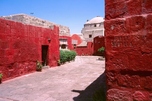 A quiet walkway lined with vivid red walls at Arequipa's Santa Catalina Convent. 