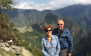 A smiling couple poses at a sunny Machu Picchu viewpoint, a perfect Peru postcard moment. 