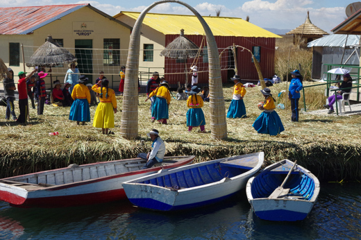 Traditional Uros islanders with reed homes and boats on Lake Titicaca in Peru. 