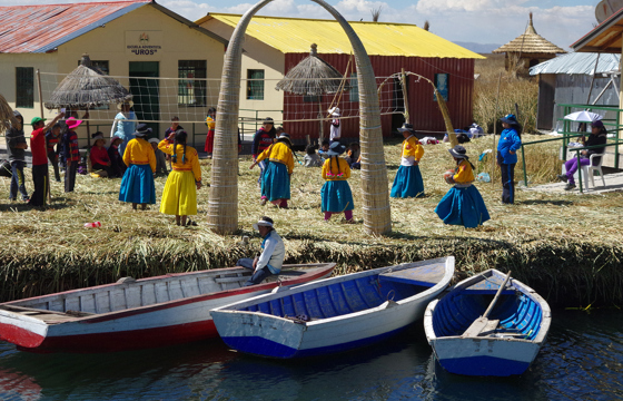 Traditional Uros islanders with reed homes and boats on Lake Titicaca in Peru. 
