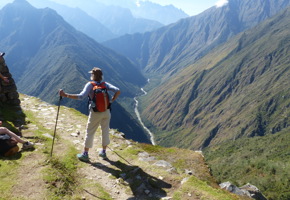 Hiker enjoying panoramic views along the Inca Trail in Peru with mountains stretching into the distance. 