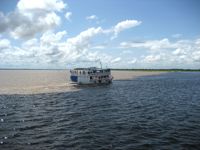 Tour boat at the Meeting of the Waters, where the Rio Negro and Amazon River flow side by side near Manaus, Brazil. 