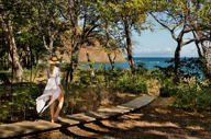Woman walking along a forest path towards the ocean at Kasiiya, Costa Rica. 