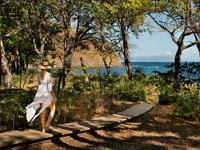 Woman walking along a forest path towards the ocean at Kasiiya, Costa Rica. 
