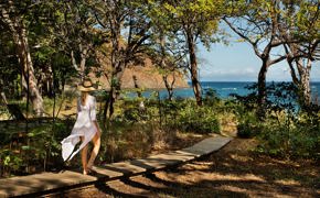 Woman walking along a forest path towards the ocean at Kasiiya, Costa Rica. 