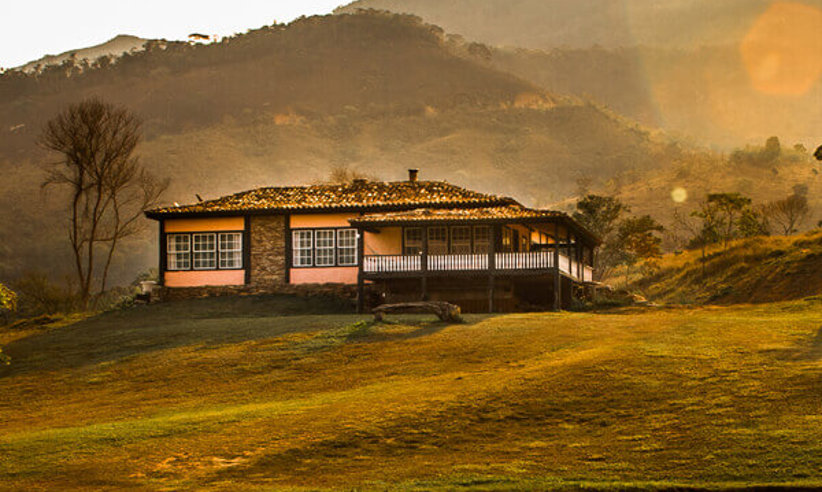 Colonial-style lodge at sunset with rolling hills in Ibitipoca, Minas Gerais, Brazil. 