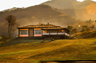 Colonial-style lodge at sunset with rolling hills in Ibitipoca, Minas Gerais, Brazil.