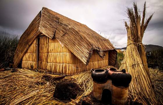 Traditional thatched reed house on a floating Uros island, Lake Titicaca, Peru. 