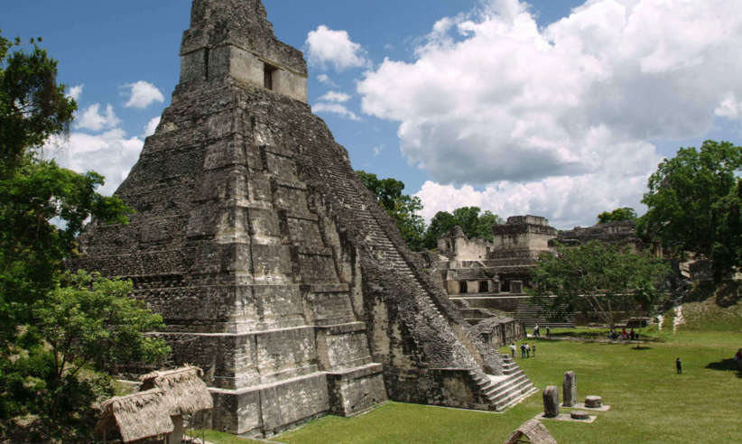 Central America, Guatemala - The towering Maya pyramid of Tikal rises above the lush jungle canopy. 