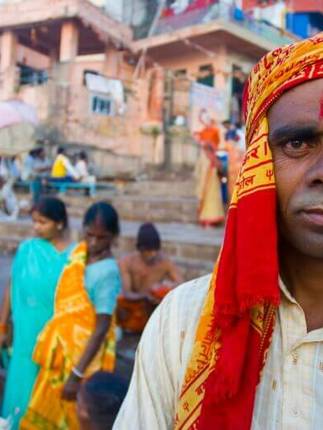 India- Local man in Varanasi at the ghats, where pilgrims gather for rituals by the sacred Ganges River. 