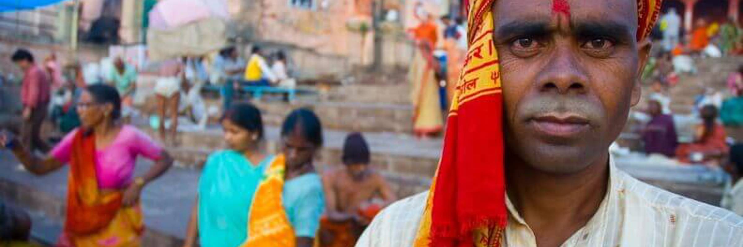 India- Local man in Varanasi at the ghats, where pilgrims gather for rituals by the sacred Ganges River. 
