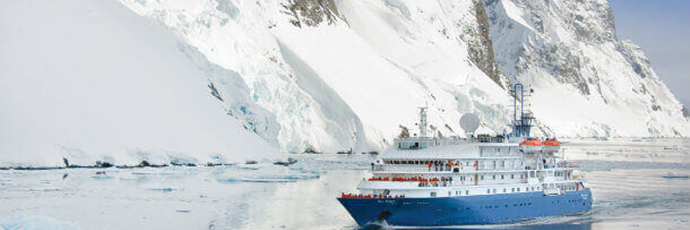The Sea Spirit cruises through Antarctica's icy water past towering glaciers. 