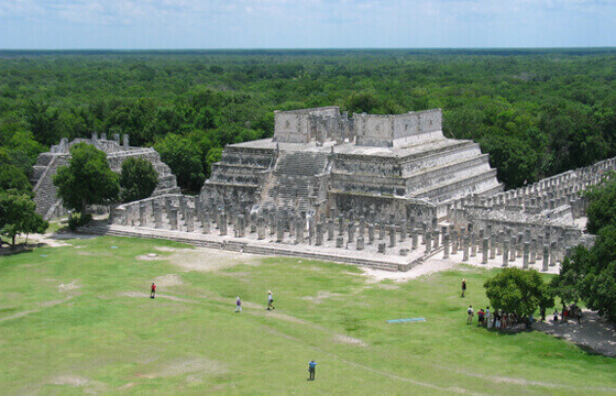 Aerial view of the Temple of the Warriors and columns at Chichen Itza, Yucatan, surrounded by lush jungle. 