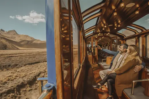 Couple enjoying scenic Andean views from the observation car of the PeruRail Titicaca Train. 