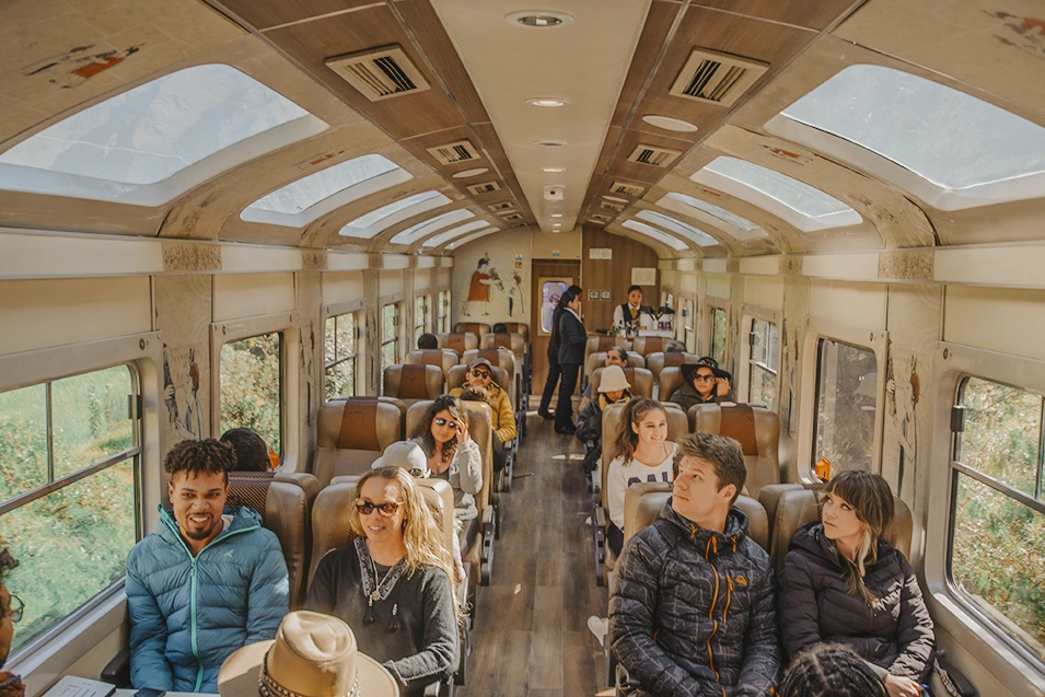 Passengers inside a panoramic train carriage en route to Machu Picchu, enjoying scenic views. 
