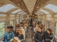 Passengers inside a panoramic train carriage en route to Machu Picchu, enjoying scenic views. 