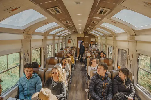 Passengers inside a panoramic train carriage en route to Machu Picchu, enjoying scenic views. 