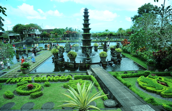 The tiered fountain and lush koi ponds of Tirta Gangga Water Palace shine amid manicured gardens in East Bali, Indonesia. 