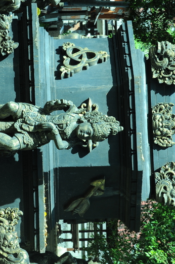 A detailed Balinese temple sculpture stands among ornate carvings in a sacred courtyard in Bali, Indonesia. 