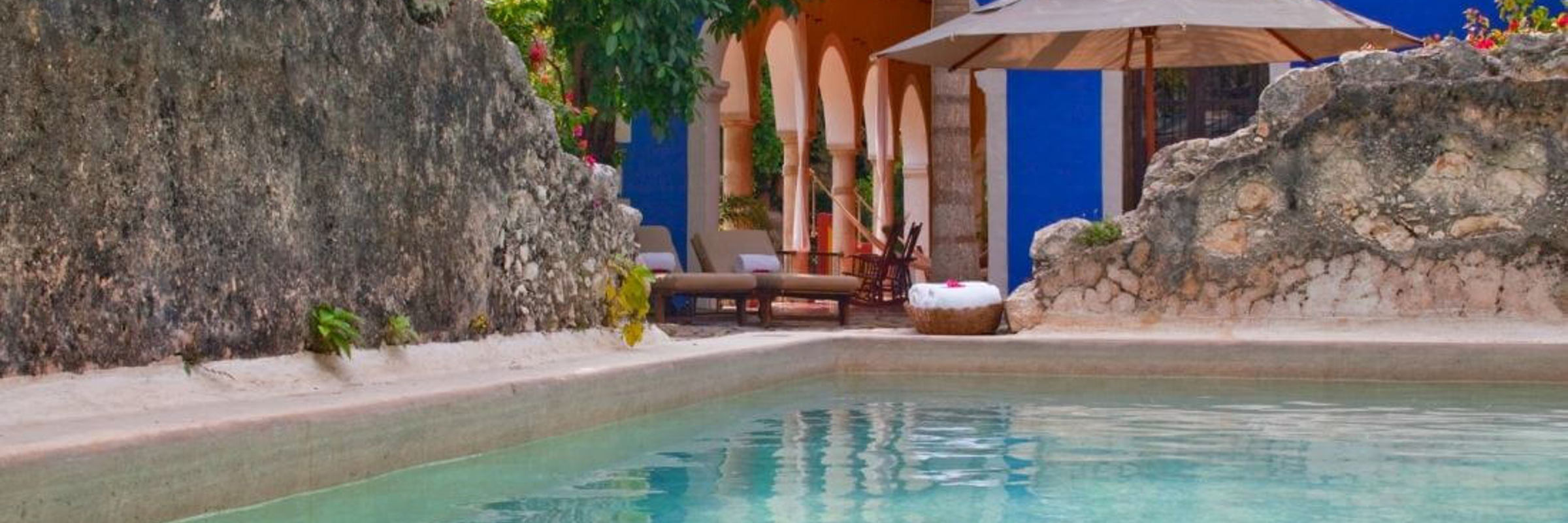 Private pool at luxury presidential suite in Mexico, surrounded by tropical gardens and a shaded palapa seating area. 