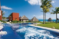 Infinity pool at Zoetry Paraiso de la Bonita Resort in Yucatan, Mexico, with ocean views and palm-lined beachfront. 