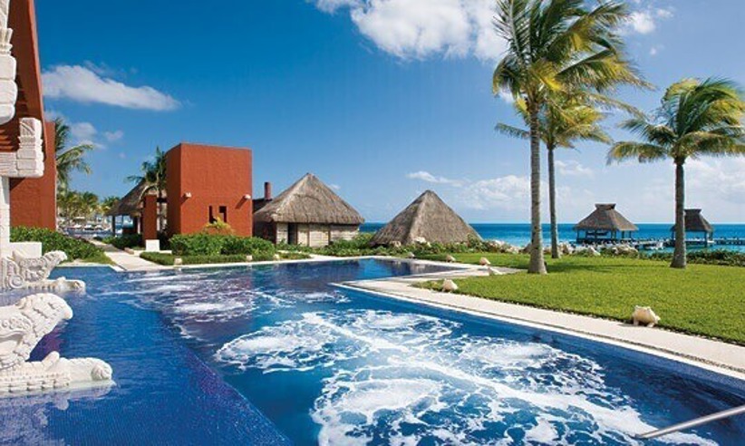 Infinity pool at Zoetry Paraiso de la Bonita Resort in Yucatan, Mexico, with ocean views and palm-lined beachfront. 