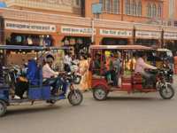 India - Colourful tuk tuks and rickshaws navigate a lively street near the market in Jaipur. 