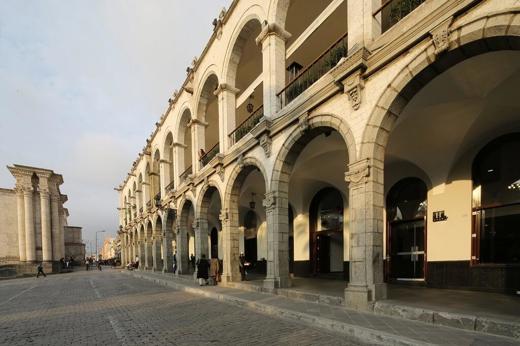 Colonial stone arches and shaded walkways of Casa Andina Select hotel in the heart of historic Arequipa, Peru. 