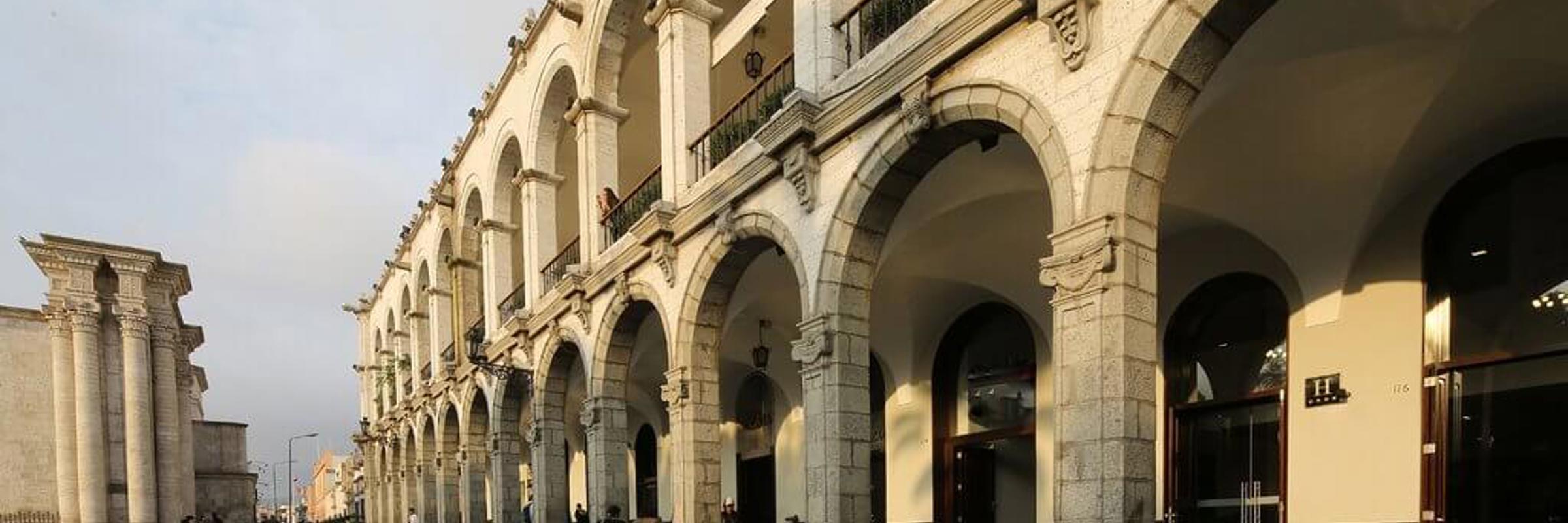 Colonial stone arches and shaded walkways of Casa Andina Select hotel in the heart of historic Arequipa, Peru. 