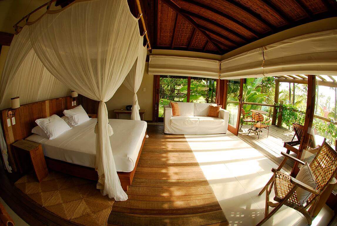 Luxury bungalow suite with canopy bed and garden views at Txai Resort, Ilheus, Bahia, Brazil. 
