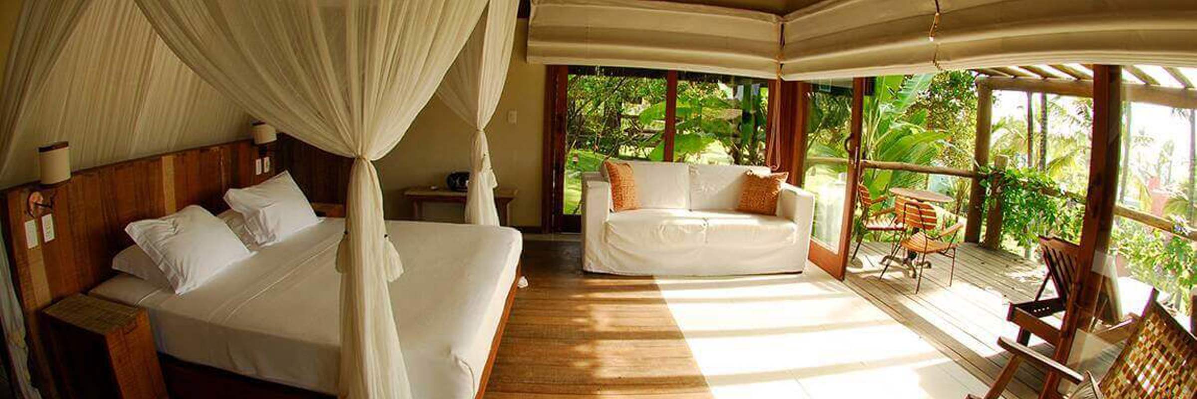 Luxury bungalow suite with canopy bed and garden views at Txai Resort, Ilheus, Bahia, Brazil. 