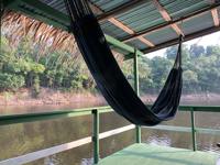Relaxing hammock with river views at Eco Park Jungle Lodge, nestled in the Amazon Rainforest near Manaus, Brazil. 