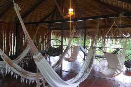 Relaxing hammock area under a thatched roof at Turtle Lodge, a jungle retreat in the Brazilian Amazon. 