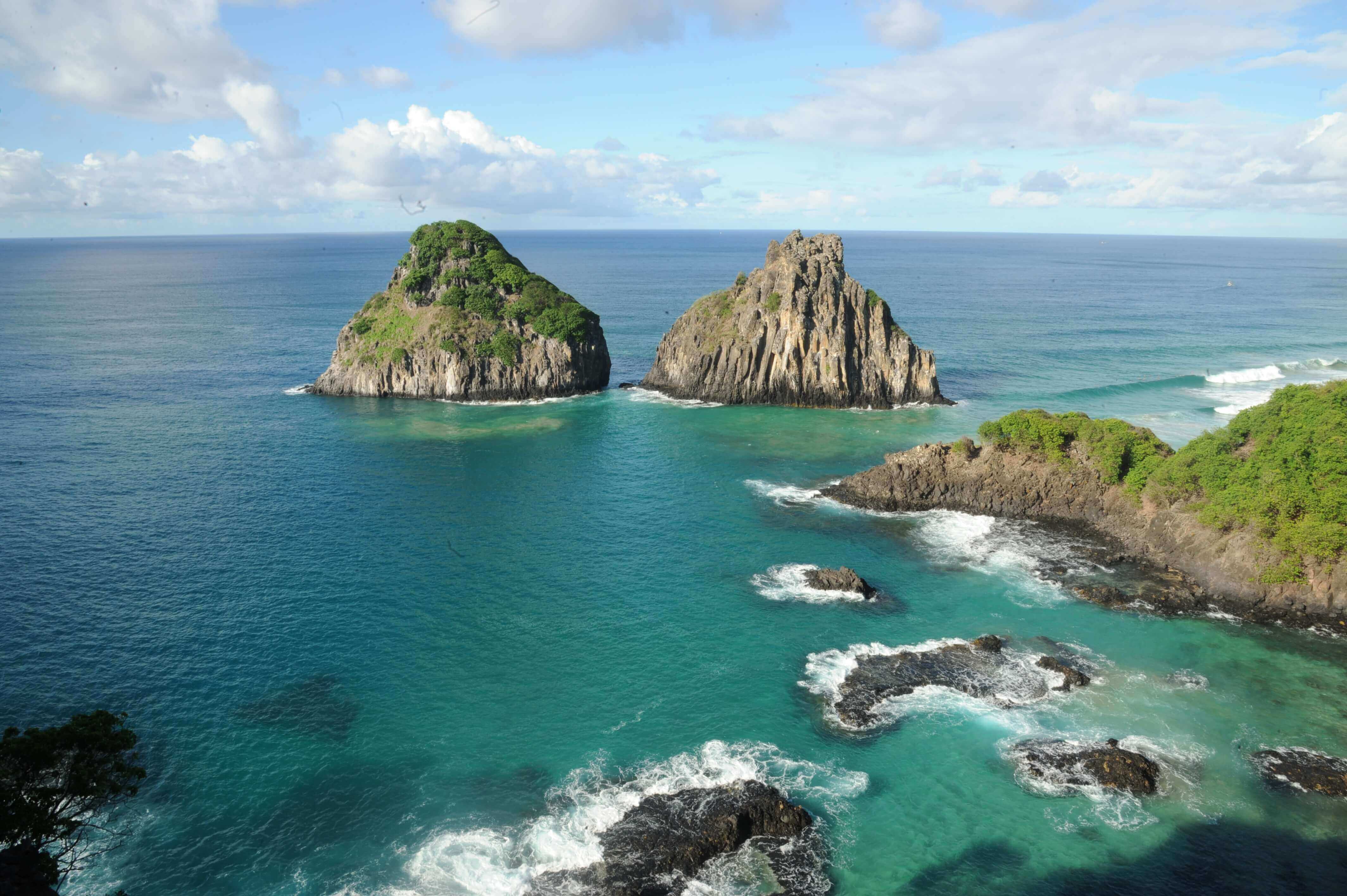 Aerial view of the Two Brothers islets rising from turquoise waters off the coast of Fernando de Noronha. 