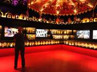 Man observing Afro-Brazilian art and artifacts in a vibrant museum exhibit in Salvador da Bahia. 