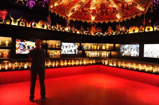 Man observing Afro-Brazilian art and artifacts in a vibrant museum exhibit in Salvador da Bahia. 