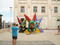 Tourists posing with colourful giant carnival head sculptures in Salvador da Bahia, Brazil. 