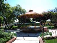 Charming bandstand in San Miguel de Allende's garden plaza, surrounded by greenery and colonial ambiance. 